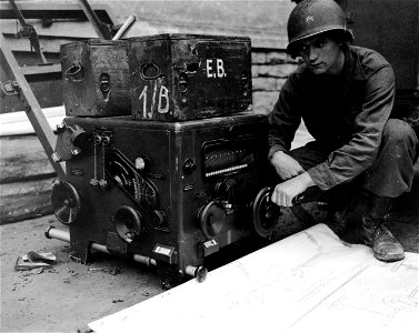 SC 330038 - Cpl. Patrick J. Shanahan, Lowell, Mass., examines one of three instruments abandoned by the Germans in their retreat from Aldesheim. photo