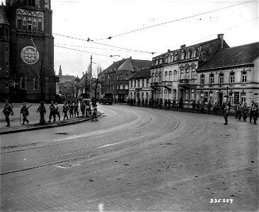 SC 335259 - Men of the 102nd Division, 9th U.S. Army, move along the road out of Krefeld, Germany, towards their new quarters along the Rhine River near Uerdingen, Germany.