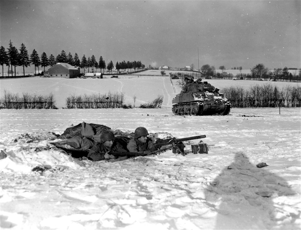 SC 364310 - Machine gunners of the 4th Armored Division* covers tank crossing snow-covered field in the Bastogne corridor. 3 January, 1945.