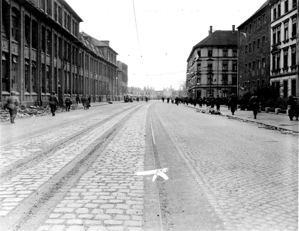 SC 335322 - "G" Co., 272nd Regiment, 69th Infantry Division, 1st U.S. Army, moves forward in newly-captured Leipzig. 18 April, 1945.