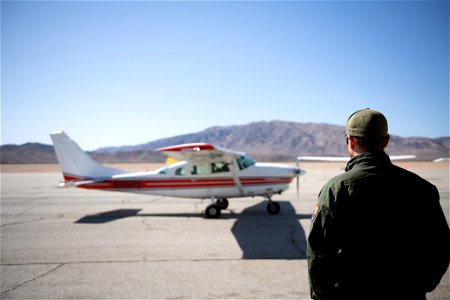 Park ranger next to NPS patrol plane photo