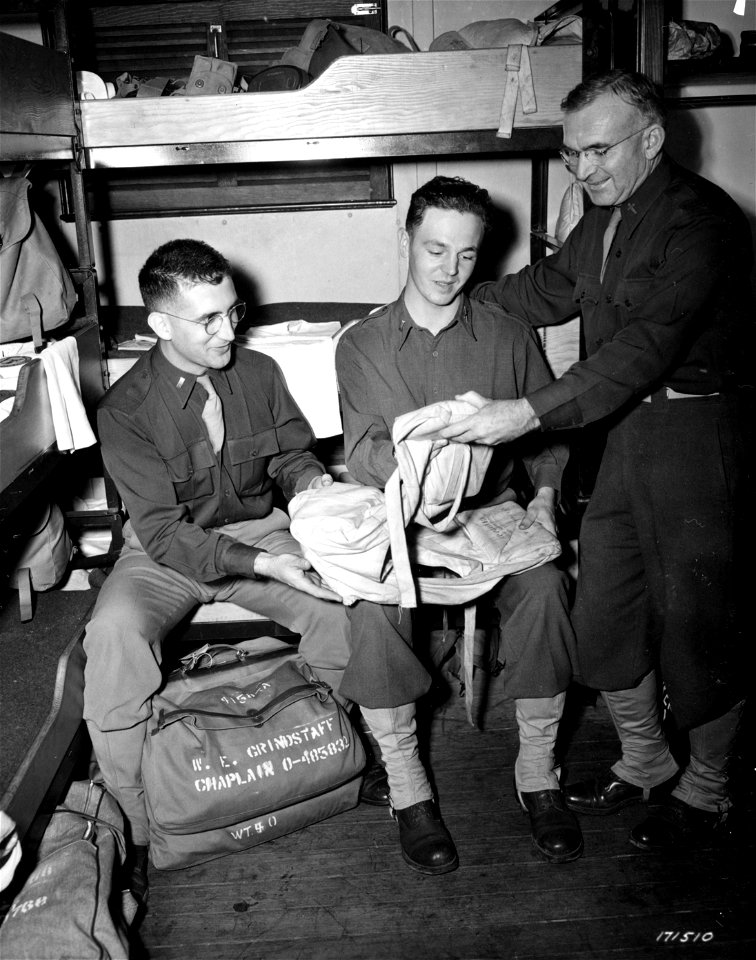 SC 171510 - Chaplain (1st Lt.) W. E. Grandstaff, Milan, Mo., 1st Lt. Jacob Winter, Inf, New York City and Chaplain (Lt. Col.) Mark T. Warner, Montrose, Colorado, examine a life jacket in their stateroom.