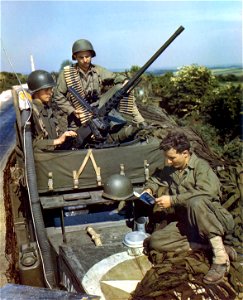 C-1078 - Three soldiers on top of a halftrack make last minute check on their guns and equipment prior to boarding a ship for the invasion. photo
