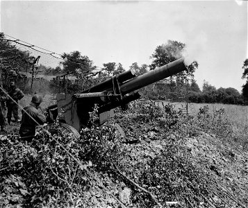 SC 364298 - A 155mm howitzer, also known as whispering death, of the 4th Infantry Division, throws another shell into the cracking German lines. 24 July, 1944. photo