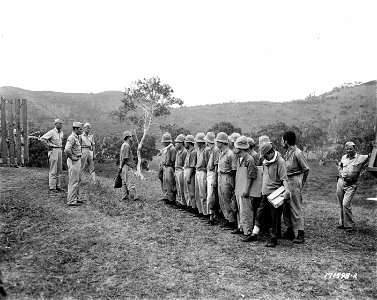 SC 171598-R - First Island Command, New Caledonia. Studiously avoiding looking at the camera, Japanese prisoners line up before entering their new stockades specially built which they were being temporarily housed in. photo