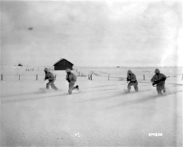 SC 374832 - Four scouts of a reconnaissance squad of the 14th Field Artillery Observation Battalion, 87th Infantry Division, 3rd U.S. Army, race through snow-covered field to avoid enemy small arms fire near Malscheid. photo