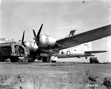 SC 270496 - Sgt. Nelson T. Young, Gonzales, La., removes the nozzle from the wing tank of a B-29 Superfortress plane as Sgt. John T. Daly, Wichita, Kan. stands by. CBI Theater, 6 December, 1944.