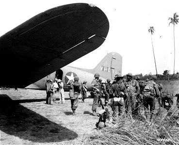 SC 166666 - On alighting from a transport plane, soldiers adjust clothing and equipment. 15 December, 1942. photo