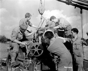 SC 364300 - The recoil section of a 155mm howitzer is lowered into place at an Army Ordnance Repair Shop behind the front lines.