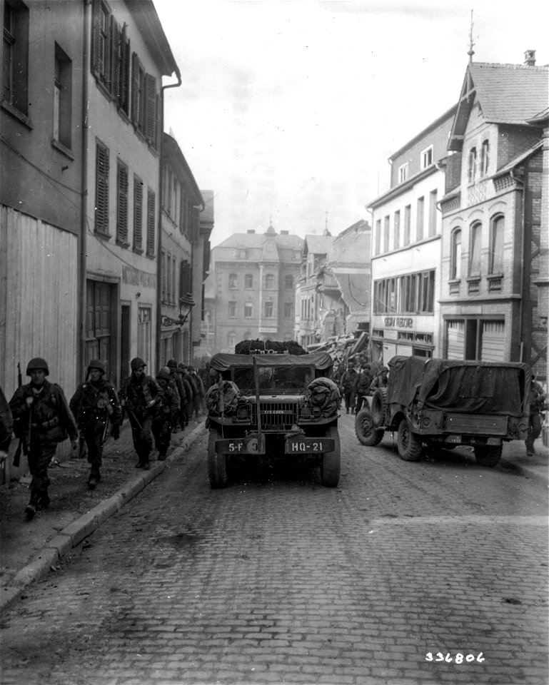 SC 336805 - Vehicles of the 5th Infantry Division, U.S. Third Army, move into the newly captured town. Simmern, Germany. 18 March, 1945.
