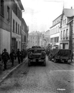 SC 336805 - Vehicles of the 5th Infantry Division, U.S. Third Army, move into the newly captured town. Simmern, Germany. 18 March, 1945.