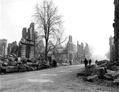 SC 335307 - Infantrymen run through streets of Heilbronn, Germany, near former bridge site, while heavy concentration of German nebelwerfer, artillery and small arms fire continually rake this section of town.