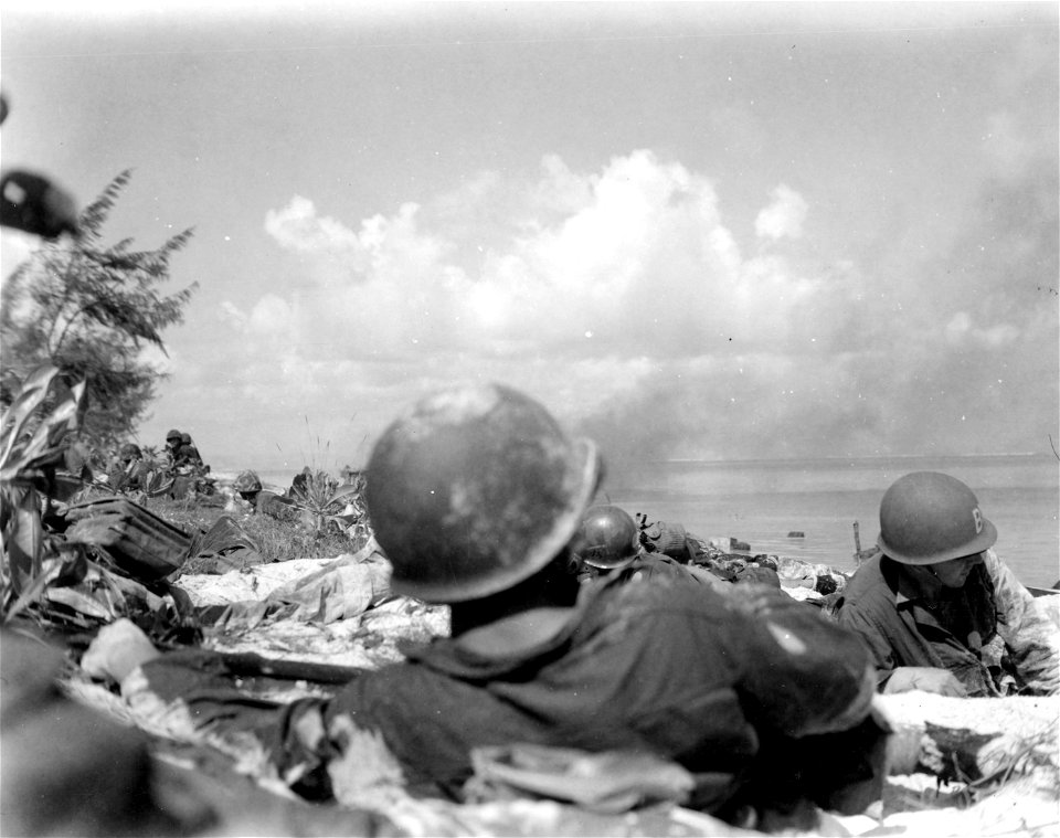 Capt. Palmer of the Marines, takes charge of situation on hitting beach. Pfc. Peck of Long Island, N.Y. on the right.