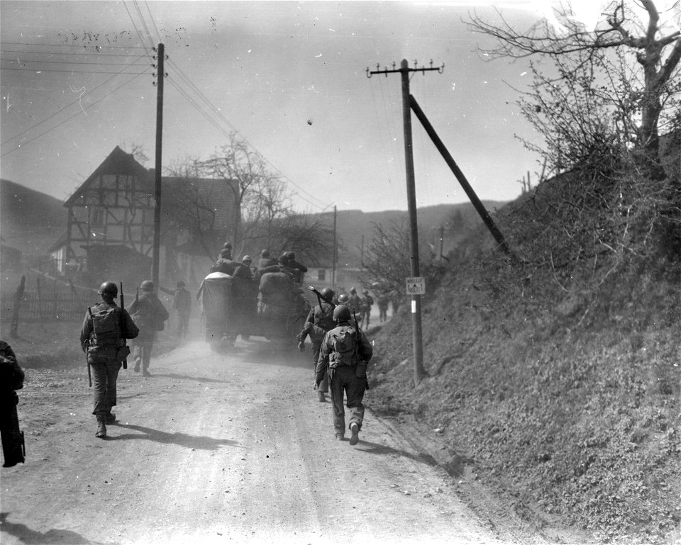 SC 270693 - Halftrack moves through two columns of infantrymen of the 5th Division, First U.S. Army, advancing along mountain road to Grevenstein, Germany, in the Ruhr Pocket.