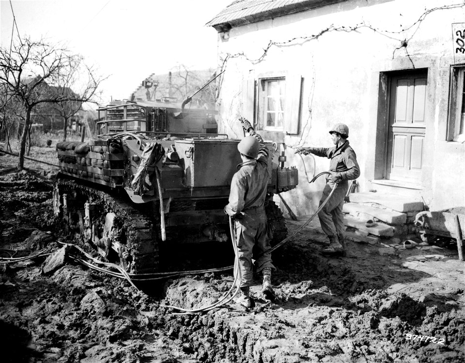 SC 374722 - Pvt. George W. Rodgers, Pittsburgh, Pa., and Cpl. Steve C. Lipinski, 84th Engineer Camouflage Battalion, attached to the 100th Division, Seventh U.S. Army, finish painting a M5-A1 tank.