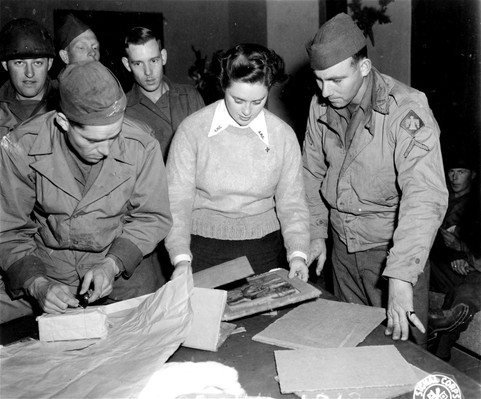 SC 329748 - Red Cross girl helping men at one of the 5th Army rest centers prepare packages for sending home. 9 January, 1944.