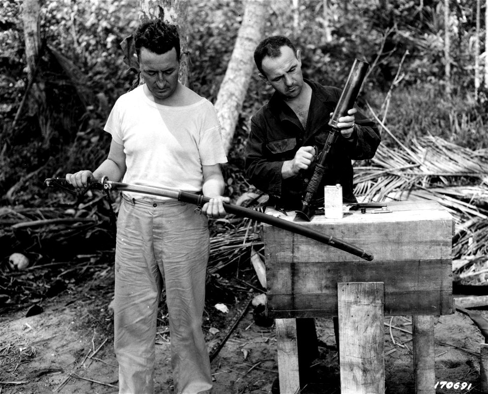 SC 107691 - Major John J. Carew examining a Japanese sword (officer's type) and Captain Emil Khail, of River, Wisc., examining a Japanese grenade thrower.
