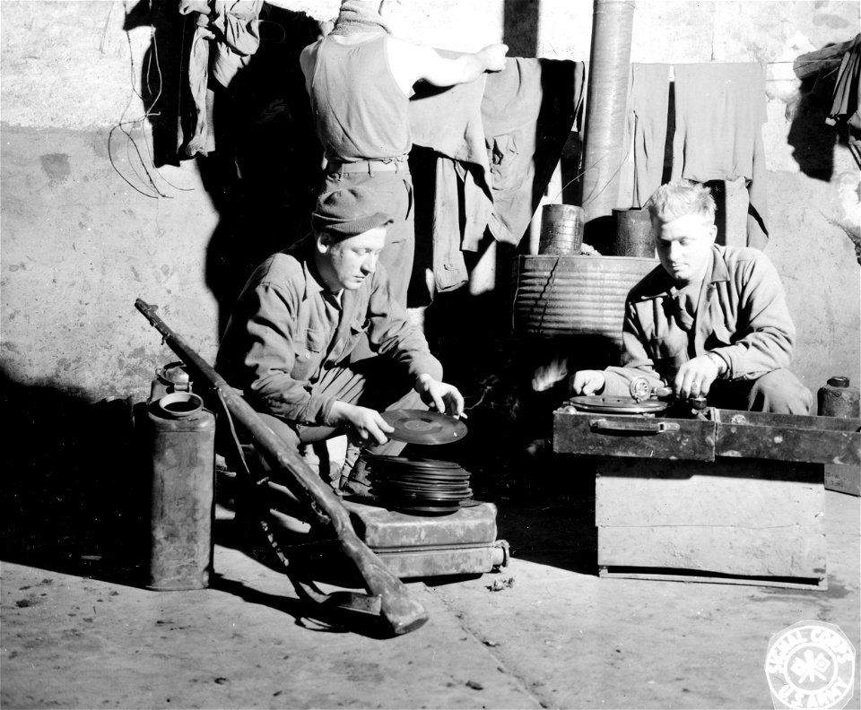 SC 196129 - U.S. soldiers listen to music from a captured German phonograph while they relax during a lull in the fighting in their sector somewhere in the European Theater of Operations.