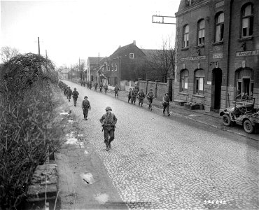 SC 336802 - Infantrymen of Company B, 406th Inf. Regt., 102nd Inf. Div., move up the road to their new out position along the Rhine River, outside the city. photo