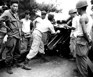SC 348631 - An ROK soldier with the 15th Regt., 1st ROK Div. swabs out 105mm howitzer after firing in action against the North Korean forces, north of Taegu. 18 September, 1950. photo
