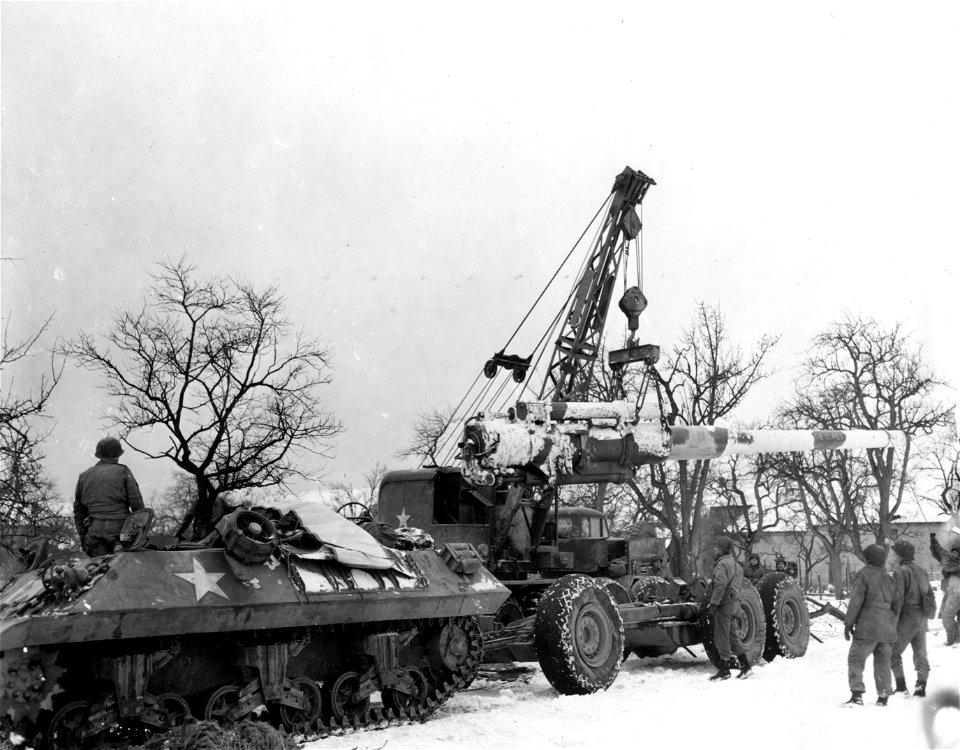 SC 199030 - Barrel of an 8 inch naval rifle, converted for land use, is removed from its trailer by men of the 243rd Field Artillery Battalion in Remeling, France. 22 January, 1945.