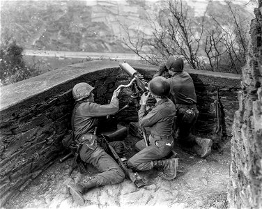 SC 364332 - Left to right: Pvt. Ray Pennington, Princetown, W.Va., Pfc. Emory Neill, Griffith, Ga., and Pfc. Howard J. Stringer, Columbia, Miss., set up their machine gun to watch and harass the Nazi movements on the other side of the Rhine... photo