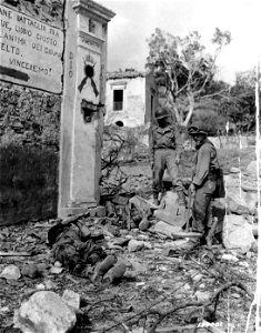 SC 180001 - A dead U.S. soldier in foreground, killed by a booby-trap attached to gate near bridge. Four were killed and 20 injured.