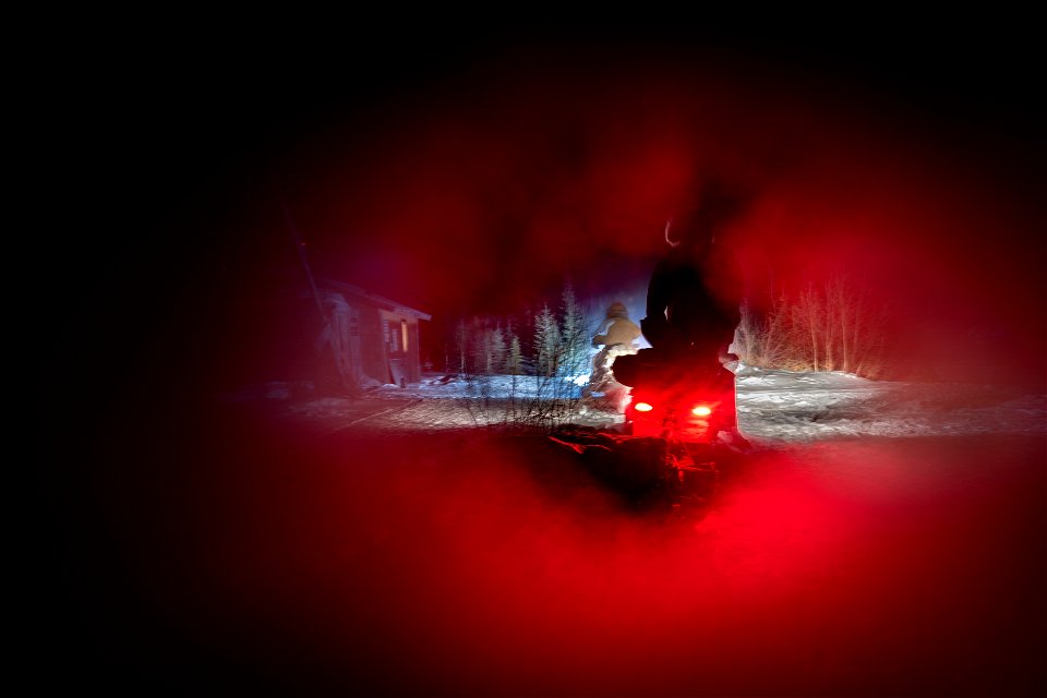 Snowmachine and sled at night
