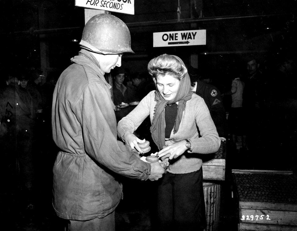 SC 329752 - Helen Beko, Red Cross worker of St. Louis, Mo., serves doughnuts to Pvt. Freeman L. Dickey, Savannah, Ga., 7th Army soldier. France, 1944.