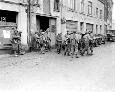SC 329951 - Infantrymen of 1st U.S. Army gather in Bastogne, Belgium, to regroup after being cut away from their regiment by Germans in the enemy drive in this area. 19 December, 1944. photo