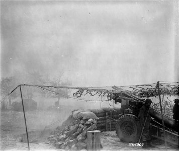 SC 364307 - Under conditions of snow and fog which makes visibility impossible, a 155mm howitzer is fired on German positions in Conzen from a location near Roetgen. photo