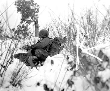 SC 199107 - Pvt. William J. Birthold of 90th Division rests before his regiment moves on over ridge near Doncols, Luxembourg. 14 January, 1945.