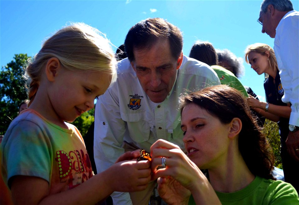 Service Director Dan Ashe helps as Hallie tags a monarch.