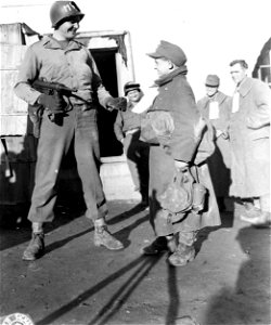 SC 195668 - Pfc. Beasel T. Marchbanks, left, of Snyder, Texas, an MP attached to an infantry unit, chats with a very young German soldier, captured by advancing American troops somewhere in France. 20 October, 1944. photo