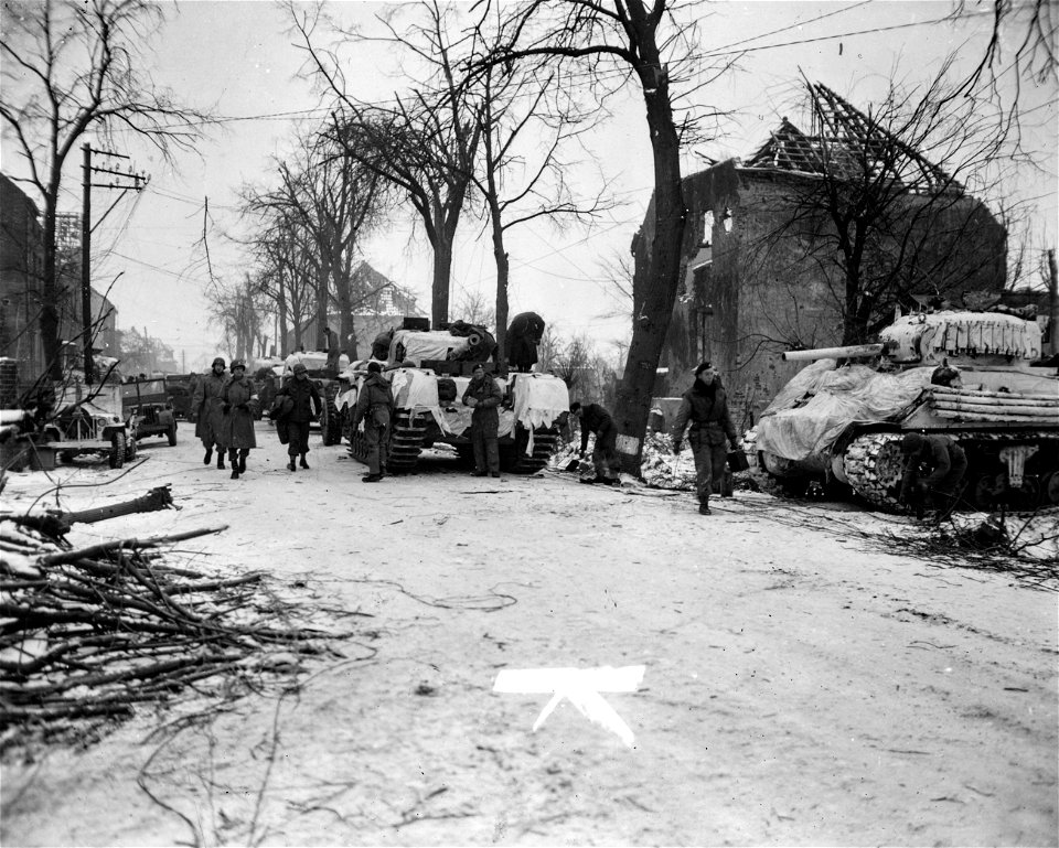 SC 334959 - American and British soldiers shown in street of Lindern, Germany, which is lined with American Sherman and British Churchill tanks.