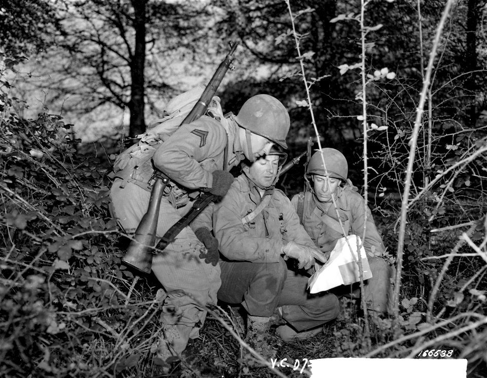 SC 166538 - Cpl. Plum, Iowa; Lt. Padfield, Fairbanks, Alaska, and Pvt. L. Gaudet, Mass., going over maps and battleplans during recent battle practice in Northern Ireland.