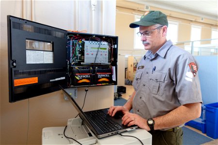 Dan Brown, Electronics Technician, works on an alarm panel