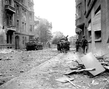 SC 195638 - Aided by the armored force, Yank infantry moves forward to engage the enemy in Aachen, Germany. 15 October, 1944.