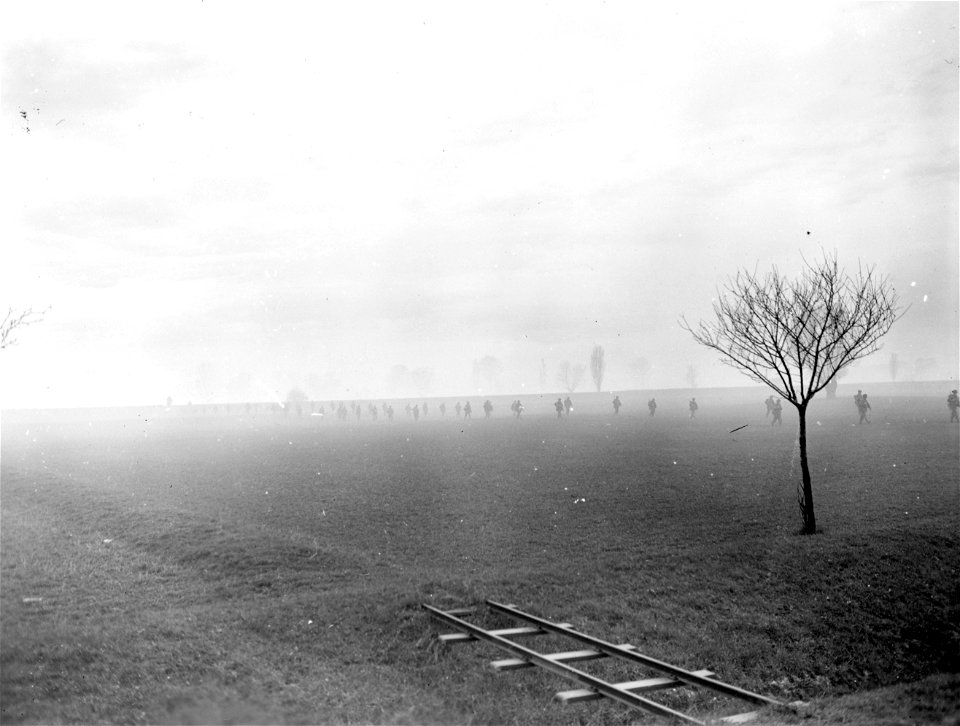 SC 270638 - Long lines of Seventh Army infantrymen, partially concealed by smoke screen, move forward to assault boats to cross the Rhine.