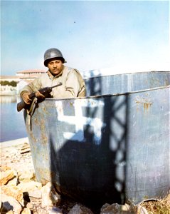 C-780 - Capt. James H. Page, Los Angeles, California, attached to the 92nd (Negro) Div., Medical Supply, stands in an incompleted ship turret bearing Nazi emblem in a shipyard near Viareggo, Italy. photo