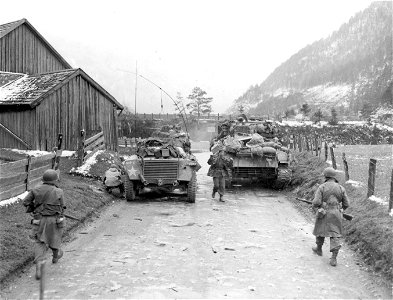 SC 337284 - (409th Task Force photo series) German comes in to advancing Yank riflemen with hands raised in surrender. 1 May, 1945. photo