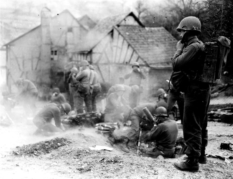 SC 337215 - Pfc. Robert N. Mausfield, Sandusky, Ohio, right, relays firing orders to mortar crew in [illegible], Germany.