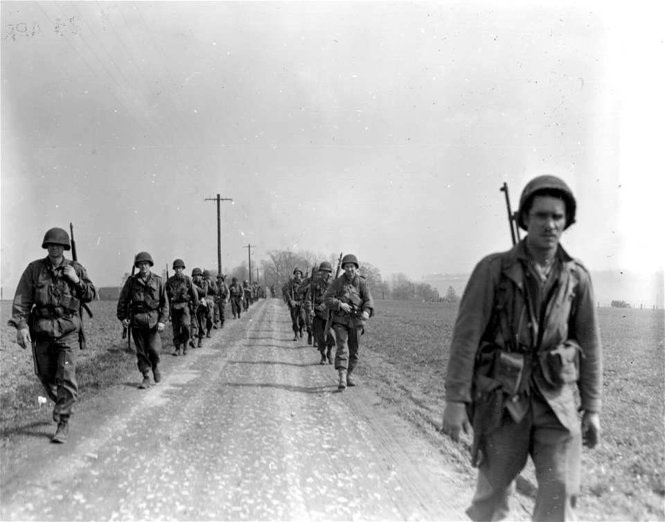 SC 270814 - Infantrymen of the 8th Infantry Division, 1st U.S. Army, move along the road outside Wergeberg, Germany. 13 April, 1945.