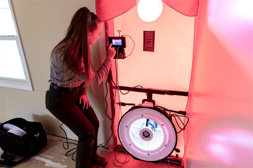 Rachel Dodgen, asset manager, turning on the blower door