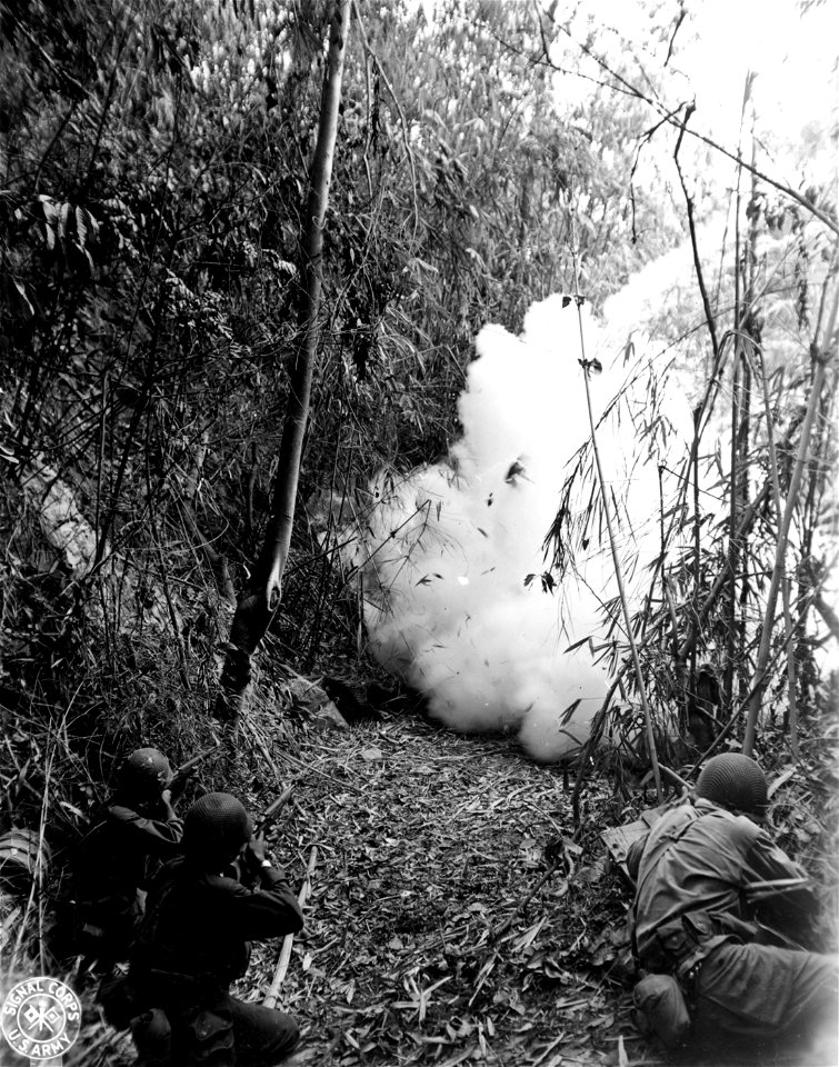 SC 270894 - Veteran infantrymen of "K" Co., 3rd Bn., 161st RCT, 25th Div., cover a Jap cave with their rifles, should the Japs decide to come out because of the phosphorous grenade thrown into the cave in Balete Pass, Luzon, P.I.