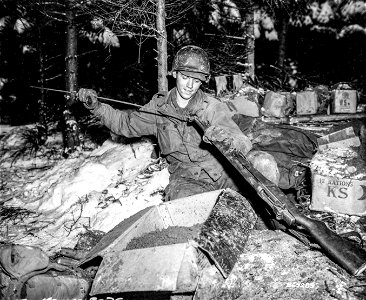 SC 364285 - Pfc. William J. Ottersbach, Louisville, Ky., a member of the 327th Glider Infantry, 3rd Battalion, 101st Airborne Division, cleans his rifle during a break near Poy, (Foy?) before pushing on to the front. photo