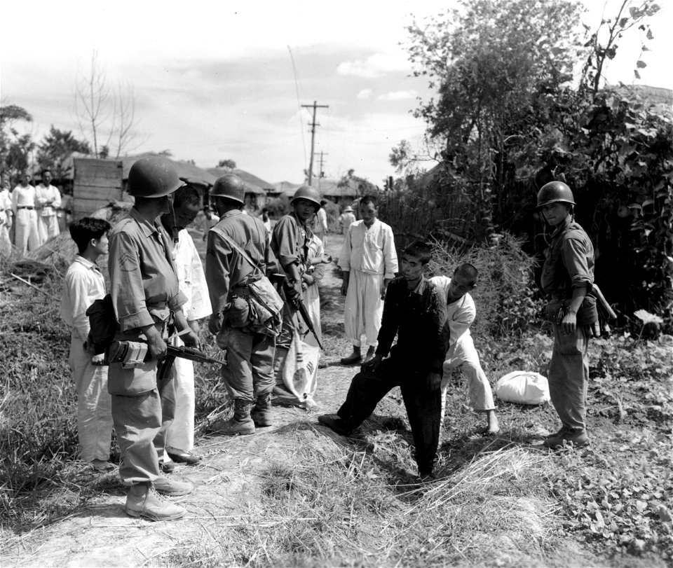 SC 349049 - ROK Marines instruct search of North Korean prisoners, flushed from hiding place, during offensive in the Han River area. 20 September, 1950.