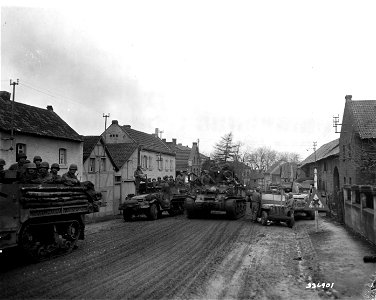 SC 336901 - Men and equipment of 9th Armored Division roll through Wusheim, Germany, in their advance to the Rhine River. 5 March, 1945. photo