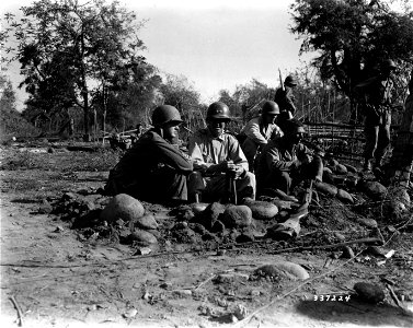 SC 337224 - Lt. Col. V. L. Johnson, G-3 Officer, 25th Division, and Maj. Gen. C. L. Mullins, Jr., CG, 25th Division, share a foxhole in San Manuel, Luzon, P.I., with a GI of the 161st Infantry Regiment. photo