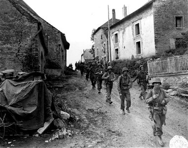 SC 270626 - Troops of the 3rd Bn., 7th Inf. Regt., 3rd Div., move through a muddy street in Montjustin-et-Velotte, France. 14 September, 1944.
